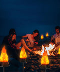Group enjoying campfire surrounded by Solar Outdoor Torch Lights With Flickering Flame For Backyard And Garden Decor Waterproof LED Pathway Lanterns For Patio Yard And Camping Eight Pack Easy Auto On Off