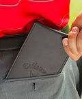 Pro Grade Leather Golf Scorecard Holder For Yardage Books being placed in back pocket, durable black card keeper with secure clip