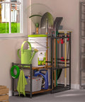 Heavy Duty Steel Garden Tool Rack With Two Tier Wooden Shelves And Six Hooks For Garage Organization Holds Up To Thirty Five Long Handled Yard Tools Durable Storage Solution To Keep Your Workshop Clutter Free with various garden tools stored at a corner window.