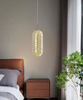 Gold Modern Crystal Pendant Light For Kitchen Island And Dining Room hangs above a bedside table, warm LED glow illuminating room