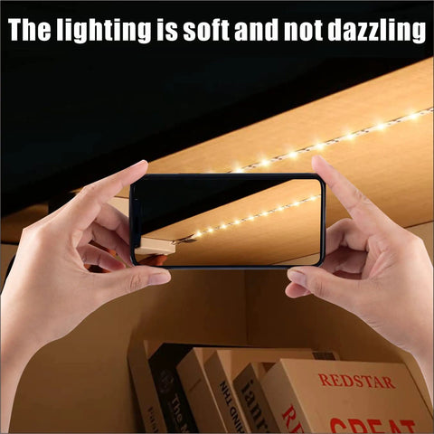 Person installing Battery Powered LED Strip Lights 3.28 Feet Two Pack For Under Cabinet Kitchen Lighting Warm White 3000K with phone.