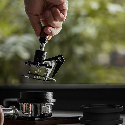 Image of 58mm Espresso Needle Distributor Features Nine Fine Thin Needles Adjustable Height Frame and Sleek Black Cleaning Base in use.