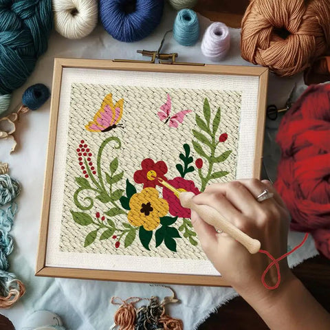 Close-up of hand using punch needle on framed cloth from Two Pack Flower Butterfly Punch Needle Kit Set With Frames For Beginners, Includes 12 Yarn Colors, Hook, Pattern And Instructions, Ideal Starter Embroidery Kit For Wall Hanging 9.4 By 9.4 Inches