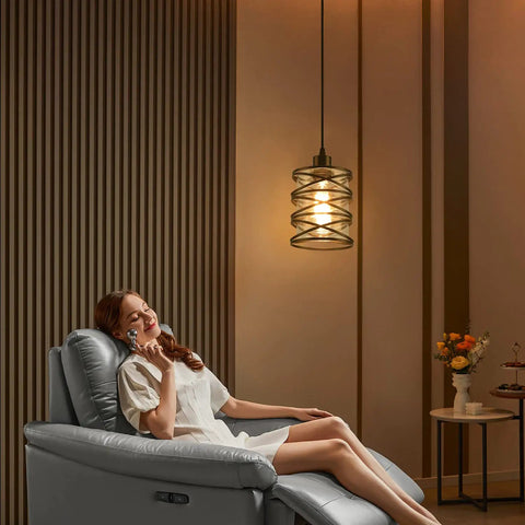 Killer Three Pack Pendant Lights For Kitchen Island And Dining Table Matte Black Spiral Cage With Clear Glass Shades Top Shelf modern pendant light above a woman relaxing in a gray recliner.