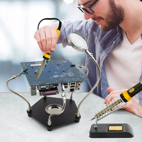 Helping Hand Soldering Third Hand Tool with flexible arms and soldering iron stand holding PCB for electronic repair on metal base.
