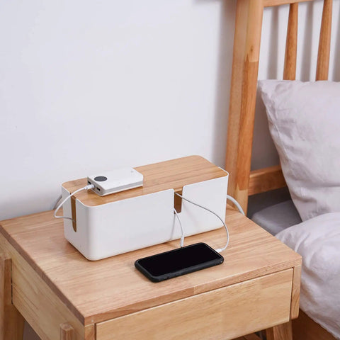 Cable Management Box With Bamboo Lid For Hiding Extension Cords And White Surge Protectors on a nightstand, tidy space