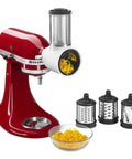Stand mixer with Game Changing Food Grinder And Fresh Prep Slicer Shredder Attachment Bundle, showing slicing blades and shredded food.