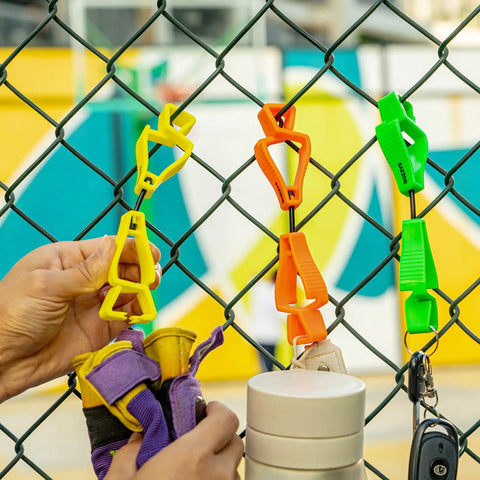 Yellow Glove Clips For Work Glove Holders 6 Pack Pro-Grade POM securing gloves on a fence, ideal for tough worksites.
