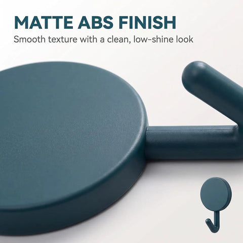 Close-up of a matte ABS finish on a wall hook, showcasing a smooth texture and a decorative design for 15 Pack Self Adhesive Wall Hooks With Hella Strong Grip No Drilling Damage Free Mounting For Towels Keys And Flatware Decorative Cutesy Style Perfect For Bathroom Office Or Closet Super Easy Setup And A Surefire Storage Winner.