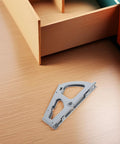Front view of 1-piece stainless steel drawer hinge mounting plate on a wooden floor