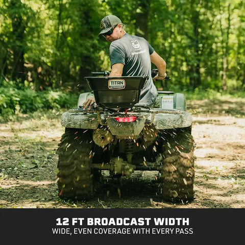 12 Volt ATV UTV Broadcast Spreader With Rain Cover 80 LB Capacity Front Or Back Mount on ATV in forest spreading seeds
