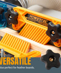 Orange feather board clamping tool on a workbench with black T-track knobs, versatile for both clamps and feather boards.