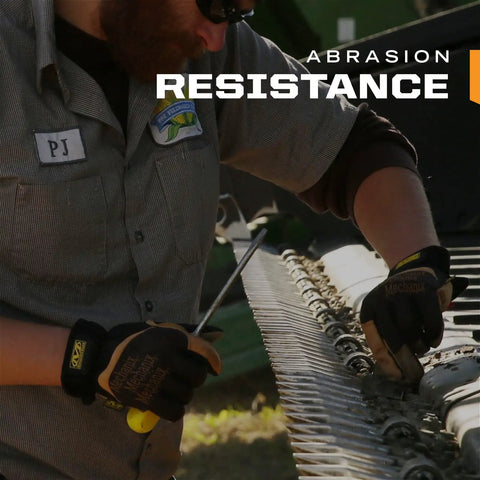 Man wearing Fastfit Leather Work Gloves That Keep Your Hands Safe And Grippy For Tough Jobs, working on machinery outdoors.