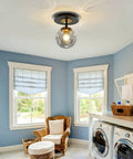 Sleek 1 Light Mini Glass Globe Ceiling Light in Black Finish Semi Flush Mount in laundry room with blue walls and wicker chair