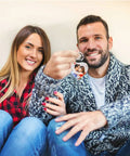Couple holding a sublimation keychain blanks set PU leather heat transfer key ring with customized photo design.