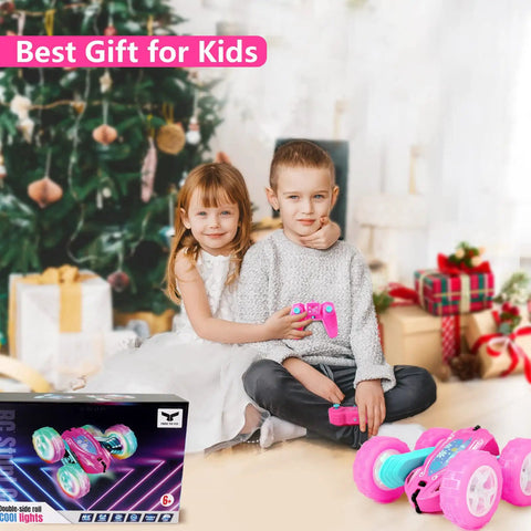 Children playing with Pink Remote Control Car For Girls That Flips 360 Degrees by Christmas tree, in a cozy room.