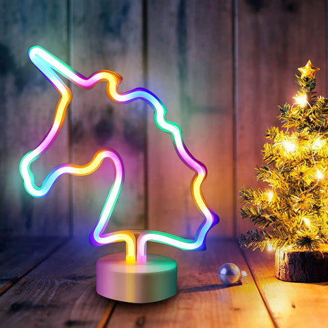 Unicorn LED Night Light For Girls Bedroom Decor Colorful Neon Unicorn Sign With USB Or Battery Power Cute Kids Room Nightlight Lit Dreamy Glow And Dope Ambience on wooden surface with mini lit Christmas tree.