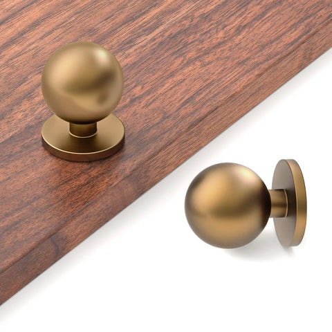 30 Pack 1 Inch Round Solid Ball Cabinet Knobs In Rich Champagne Bronze Finish on wooden surface, showcasing modern design and tight fit.
