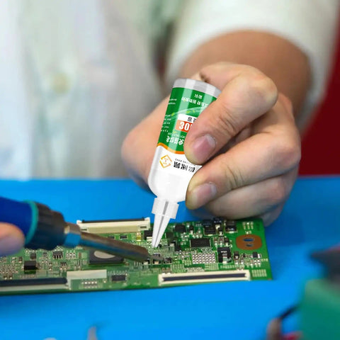 Person applying Pro Grade Aluminum Soldering Flux Liquid for Quick Dry Welds on a circuit board, showing precise application.