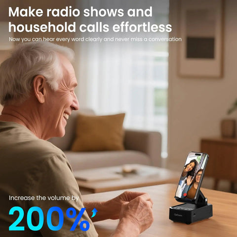 Cell Phone Stand With Instant Wireless Induction Speaker 1 Second Connection And No Pairing Needed All In One Desk Gadget With Bluetooth Speaker Phone Holder And 2000mAh Emergency Power Bank Perfect Gift For Men Women Dad Mom on a wooden table next to a smiling person using video call feature.