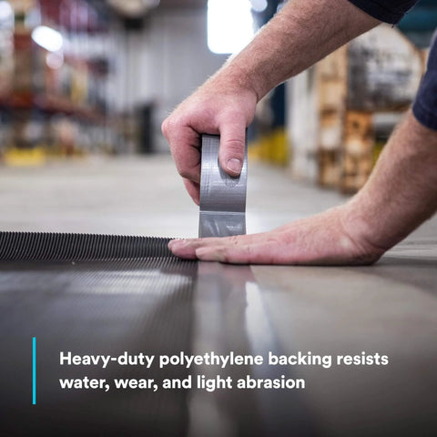 Applying Heavy Duty Duct Tape DT11 Silver 48 mm x 54.8 m (11 mil) on industrial surface, showcasing strength and adhesive grip