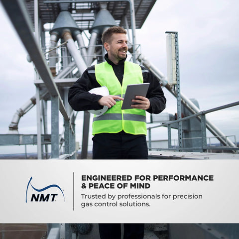 Natural gas regulator NMT NGR02-75 banner at industrial gas facility; worker in high-visibility vest uses tablet