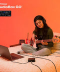 Person uses Ultra Compact USB C 2x2 Audio Interface Bundle With Condenser Microphone Studio Headphones Grab And Go Boom Stand Pop Filter XLR Cable And Studio One Music Production Software for music production on bed