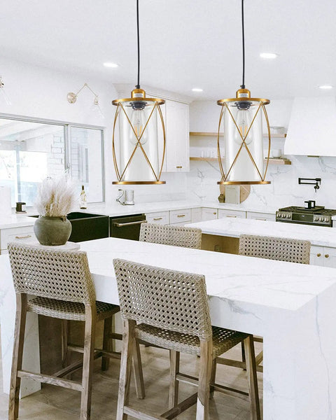 Modern Brushed Brass Mini Pendant Light With Clear Glass Shade 1-Light in kitchen over island, wicker chairs below