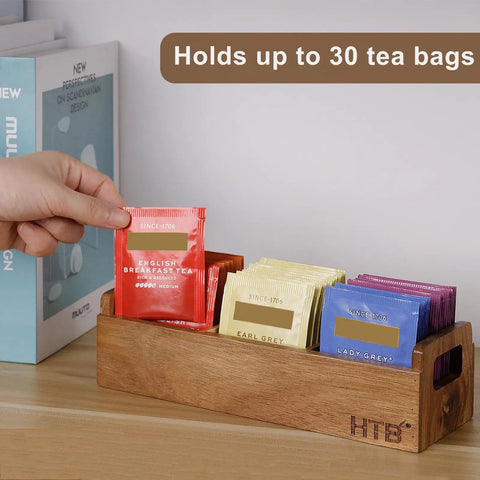 Person organizing tea bags in Three Compartment Wooden Tea Bag Box With Handle Acacia Wood Caddy for countertop storage.