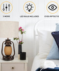 Bedroom setting with a Set Of 2 Farmhouse Table Lamps With Dual USB Charging Ports And 4 Way Rotary Switch, Rustic Metal Nightstand Lights, Beige Linen KD Fabric Drum Shade on a white nightstand, emphasizing warm ambient lighting and device charging convenience.