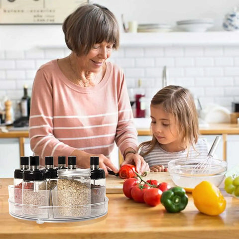 Clear 11 Inch Lazy Susan Organizer With Five Removable Bins on kitchen counter with spices, next to woman and child cooking.