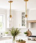 Two Pack Brass Pendant Lights With Clear Glass Globe Shades Farmhouse Gold Hanging Lamps For Kitchen Island Dining Room And Entryway, elegant kitchen setting.