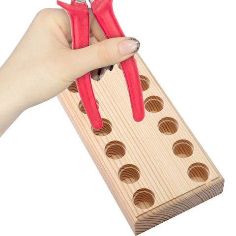 Hand holding pliers next to Wood Pliers Holder With Multi Slot Rack For Beading Tools And Hand Tools Durable Bead Tool Organizer