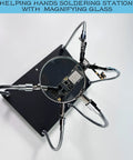 Top view of Helping Hands Soldering Station With Magnifying Glass 2.5X, featuring 4 flexible arms holding a PCB.