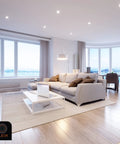 Modern living room with large windows and stylish furniture, brightly lit by GU24 Base 23W CFL Bulbs 1600 Lumens Warm White 3500K