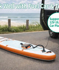Fast Inflate Electric Paddle Board Pump with Auto Off No Fuss 20 Psi High Pressure on a beach next to a car with 12V plug in