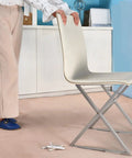 Person using 16 Piece Self Stick Furniture Sliders For Carpet Floors on a chair leg for easy movement across carpet.