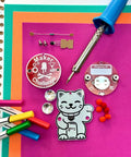 Interactive Transistor Cat Soldering Kit for Beginners and Teens with PCB, soldering iron, and colorful markers.