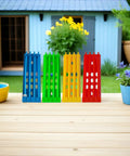 4 Pack Pigeon Ring Stands And Poultry Leg Band Racks in blue, green, yellow, and red on wooden table, garden background.