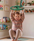 Child playing with Twister Swing Spins Set With 360 Degree Steering Wheel Design Slackline Attachments in a playroom