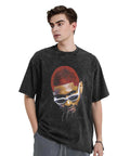 Person wearing a black T-shirt with a graphic of a man in sunglasses and red hair, standing against a neutral background.