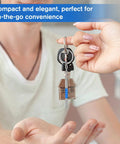 Person handing a Handy 3-In-1 Eyeglass Repair Kit With Keychain Screwdrivers, stainless steel mini toolset, featuring house charm.