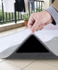 Hand lifting corner of rug showing 16 Pack Rug Gripper Pads For Hardwood Floors And Tile Non Slip Double Sided Tape Reusable No Residue