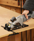 Inequalit mini circular saw, gray corded handheld tool with 4-1/2 in blade and laser guide, side view on wood workbench