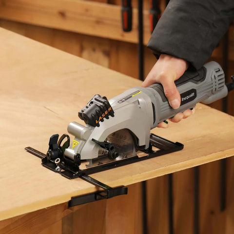 Inequalit mini circular saw, gray corded handheld tool with 4-1/2 in blade and laser guide, side view on wood workbench