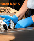 Blue nitrile gloves being worn by a worker handling seafood at a stainless prep station