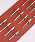 Aluminum Blind Rivets Set 1/4 By 1/2 Inch Large Flange Pull Rivets Self Plugging Pop Rivets Kit, arranged in rows on a red background