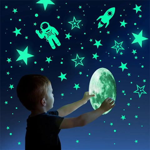 Child interacts with Glow In The Dark Stars And Planets Ceiling Wall Decor Kit With Rockets And Astronauts for a galaxy-themed room.