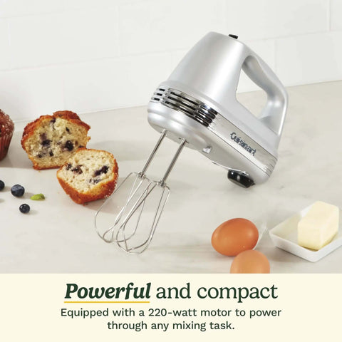 Heavy Duty Electric Hand Mixer With Nine Speed Options And A Mighty 220 Watt Motor That Glides Using Smooth Start Mode Plus Extra Long Stainless Beaters And A Simple One Touch Button For Fast No Sweat Cooking Prep next to baked goods and ingredients.