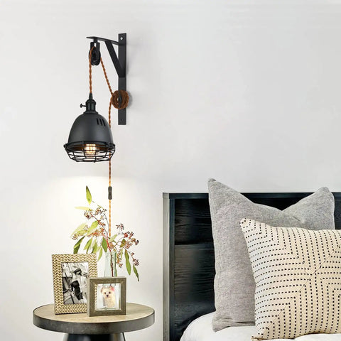 Vintage Industrial Wheel Pulley Wall Mount Lamp Set Of 2 with plug in 7 foot brown cord above bedside table.